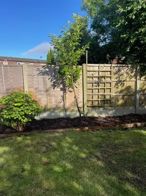 a fence with a tree in front of a yard at 1 Bed Apartment With Private Garden in Southport