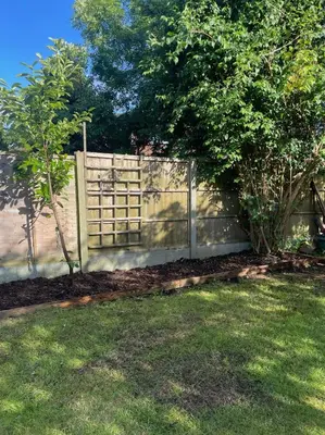 a fence in a yard next to a tree at 1 Bed Apartment With Private Garden in Southport