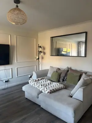 a living room with a couch and a mirror at 1 Bed Apartment With Private Garden in Southport