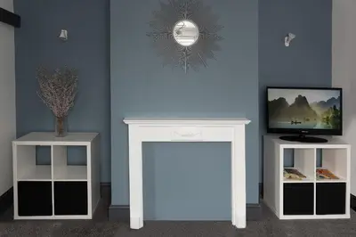 a white console table with a tv and two tables at Stylish 3 bedroom Wigan House sleeps 7 in Pemberton