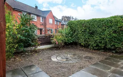 a home with a garden in front of a building at Stylish 3 bedroom Wigan House sleeps 7 in Pemberton