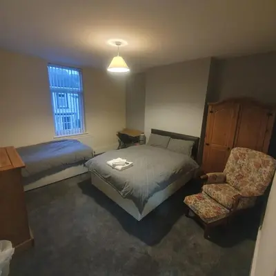 a bedroom with a bed and a chair and a window at Mount Pleasant Town House Gem in Barrow