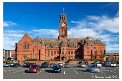 a large brick building with a clock tower and a parking lot at Mount Pleasant Town House Gem in Barrow