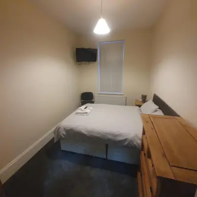 a small bedroom with a bed and a dresser at Mount Pleasant Town House Gem in Barrow