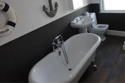 a bathroom with a tub and a sink and a toilet at Seaview Cottage Lake District Coast in Millom