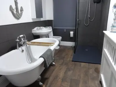 a bathroom with a tub and a sink and a toilet at Seaview Cottage Lake District Coast in Millom