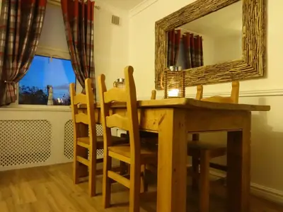 a dining room table with chairs and a mirror at Seaview Cottage Lake District Coast in Millom