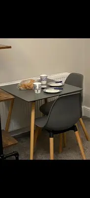 a table with a chair and a table with a loaf of bread at Cambridge Villa St Annes in Lytham St Annes