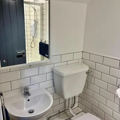 a white bathroom with a toilet and a sink at Cosy Parbold Apartment Steps form train station in Parbold