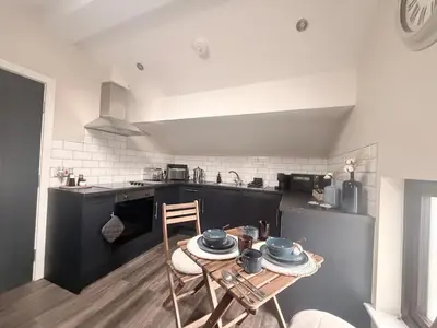 a kitchen with a table with dishes on it at Cosy Parbold Apartment Steps form train station in Parbold