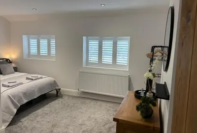 a bedroom with a bed and two windows and a table at Couples - Retreat Dog Friendly in Appley Bridge