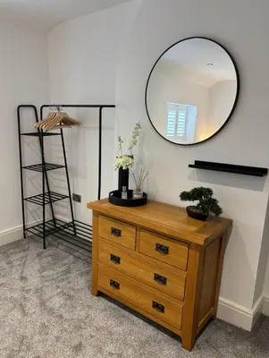a wooden dresser with a mirror on a wall at Couples - Retreat Dog Friendly in Appley Bridge