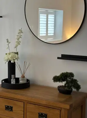 a wooden dresser with two potted plants and a mirror at Couples - Retreat Dog Friendly in Appley Bridge