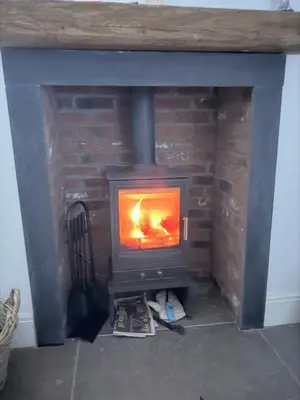 a wood stove in a brick fireplace in a room at Couples - Retreat Dog Friendly in Appley Bridge