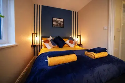 a bedroom with a blue and yellow bed with pillows at Preston Central in Preston