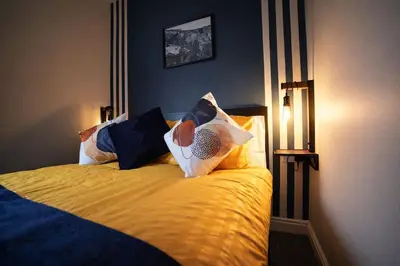 a bedroom with a bed with yellow sheets and pillows at Preston Central in Preston
