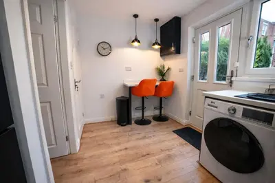 a kitchen with two orange chairs and a table at Preston Central in Preston