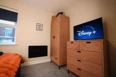 a bedroom with a dresser and a tv on a dresser at Preston Central in Preston