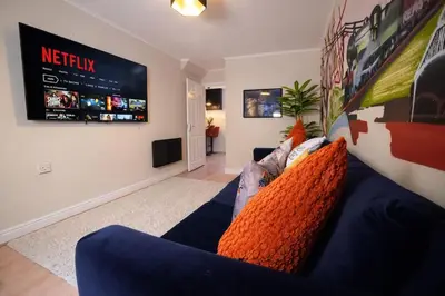 a living room with a blue couch and a tv at Preston Central in Preston