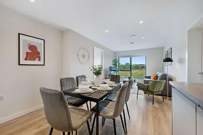 a dining room and living room with a table and chairs at Modern 2BR 2BA Apartment in Liverpool - Sleeps 4 in Liverpool