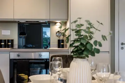 a kitchen with a table with glasses and a vase with a plant at Modern 2BR 2BA Apartment in Liverpool - Sleeps 4 in Liverpool