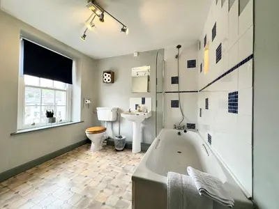 a bathroom with a tub and a toilet and a sink at Ulverston Cozy Cottage Retreat in Ulverston