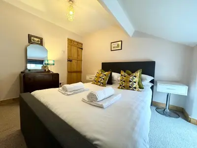a bedroom with a bed with two towels on it at Ulverston Cozy Cottage Retreat in Ulverston