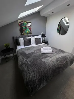 a bedroom with a large bed and a mirror at City Centre Duplex Apartment Liverpool in Liverpool