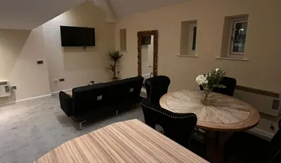 a living room with a table and a television at City Centre Duplex Apartment Liverpool in Liverpool