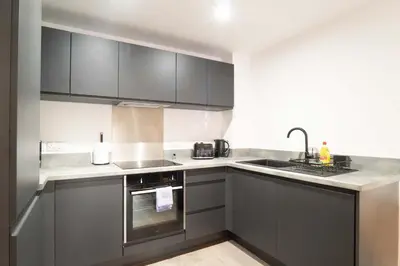a kitchen with gray cabinets and a sink at Modern 2BED 5th Floor Apartment Central Liverpool in Liverpool