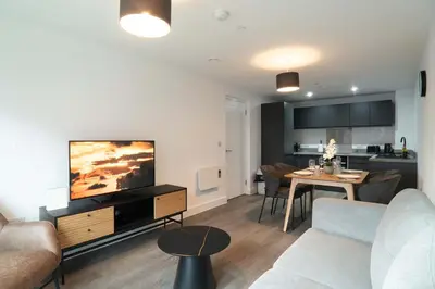 a living room with a couch and a tv and a table at Modern 2BED 5th Floor Apartment Central Liverpool in Liverpool