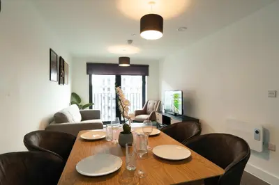a living room with a wooden table and chairs at Modern 2BED 5th Floor Apartment Central Liverpool in Liverpool