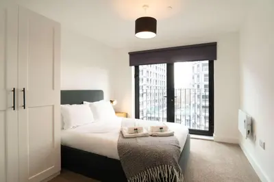 a bedroom with a bed and a large window at Modern 2BED 5th Floor Apartment Central Liverpool in Liverpool