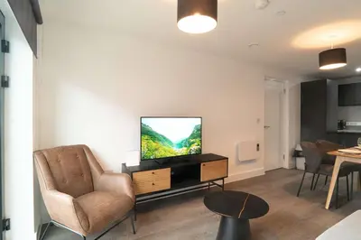 a living room with a flat screen tv on a dresser at Modern 2BED 5th Floor Apartment Central Liverpool in Liverpool
