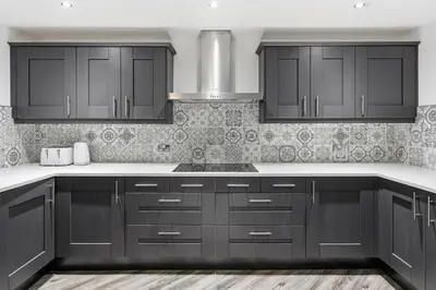 a kitchen with black cabinets and white counter tops at Skyline Penthouse- Views, Games 2 Parking Spaces in Liverpool