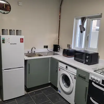a kitchen with a refrigerator and a washing machine at Ince House in Liverpool