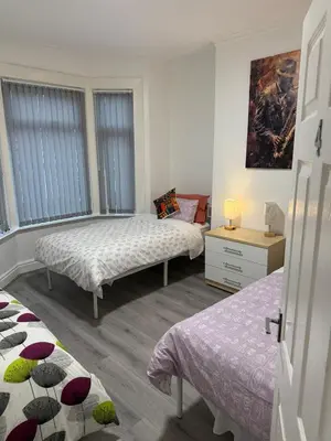 a bedroom with two beds and two windows at Ince House in Liverpool