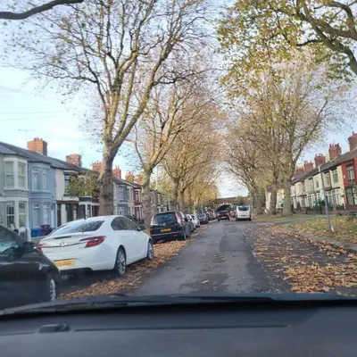 a street with cars parked on the side of a road at Ince House in Liverpool