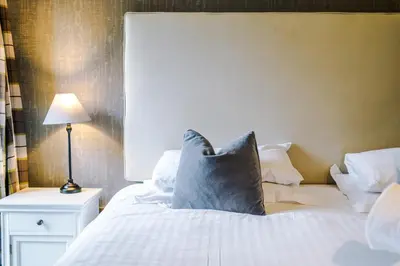 a bed with a blue pillow on top of it at Slyne Lodge in Hest Bank