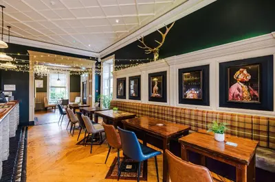 a restaurant with wooden tables and chairs in a room at Slyne Lodge in Hest Bank