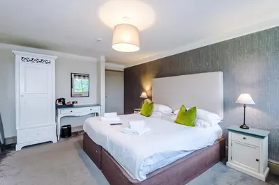 a bedroom with a large white bed with green pillows at Slyne Lodge in Hest Bank