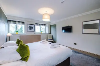 a bedroom with two beds and a flat screen tv at Slyne Lodge in Hest Bank