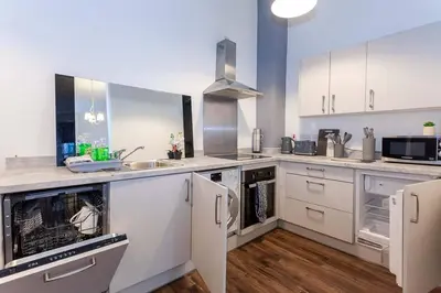a large kitchen with white appliances and wooden floors at Spacious 2BR -Liverpool Central - Walk to Royal Dock, Nightlife Train Station in Liverpool