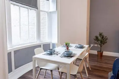 a white dining room with a white table and chairs at Spacious 2BR -Liverpool Central - Walk to Royal Dock, Nightlife Train Station in Liverpool