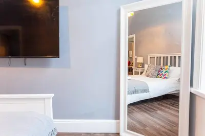 a mirror in a room with a bed and a couch at Spacious 2BR -Liverpool Central - Walk to Royal Dock, Nightlife Train Station in Liverpool