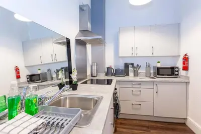 a kitchen with white cabinets and a sink at Spacious 2BR -Liverpool Central - Walk to Royal Dock, Nightlife Train Station in Liverpool