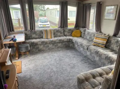 a living room with a sectional couch in a caravan at Spacious Caravan Morecambe Parkdean caravan Park in Morecambe