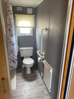 a small bathroom with a toilet and a window at Spacious Caravan Morecambe Parkdean caravan Park in Morecambe