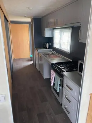a small kitchen with a stove and a sink at Spacious Caravan Morecambe Parkdean caravan Park in Morecambe