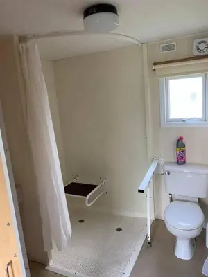 a bathroom with a toilet and a window at Spacious Caravan Morecambe Parkdean caravan Park in Morecambe